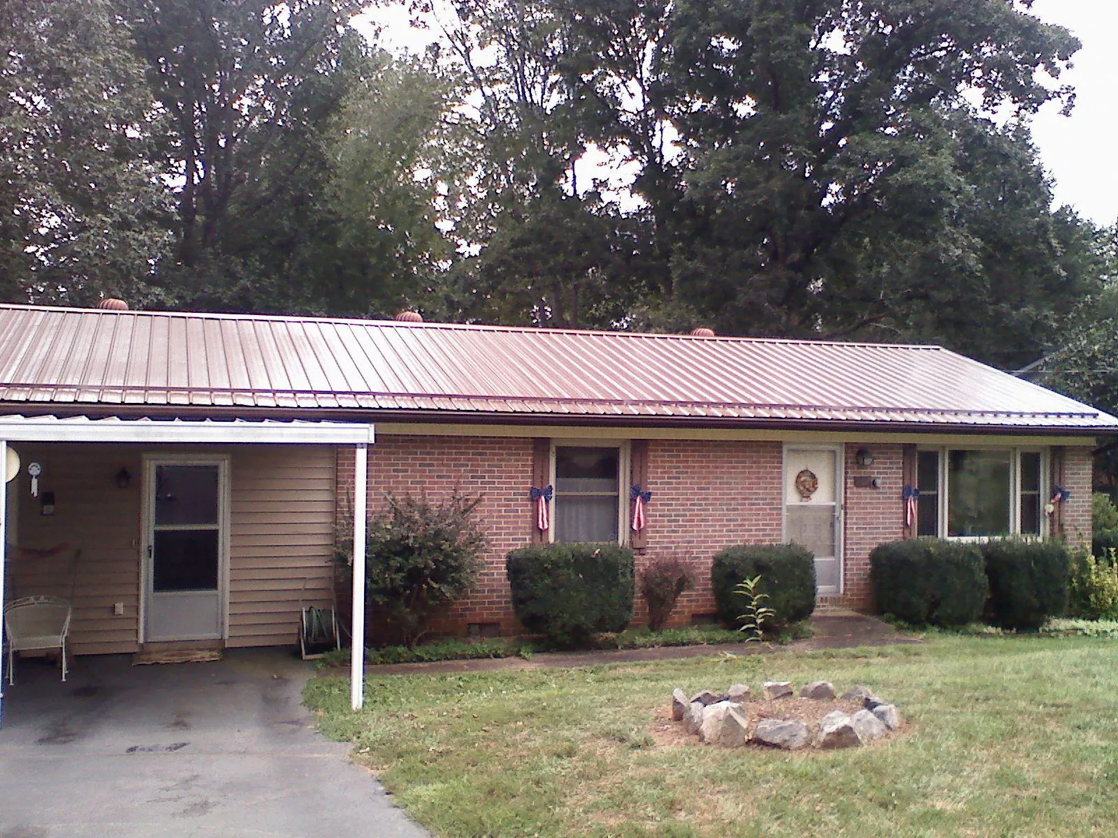 Bronze metal roof and carport on a brick ranch home — Roof Repair work by our crew in Ramer